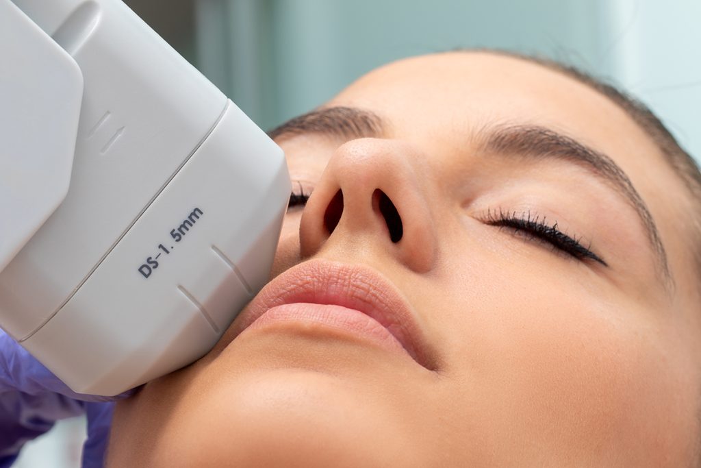 Extreme close up of HIFU treatment on female face. Therapist doing cosmetic plasma lift with high intensity focal ultrasound device.