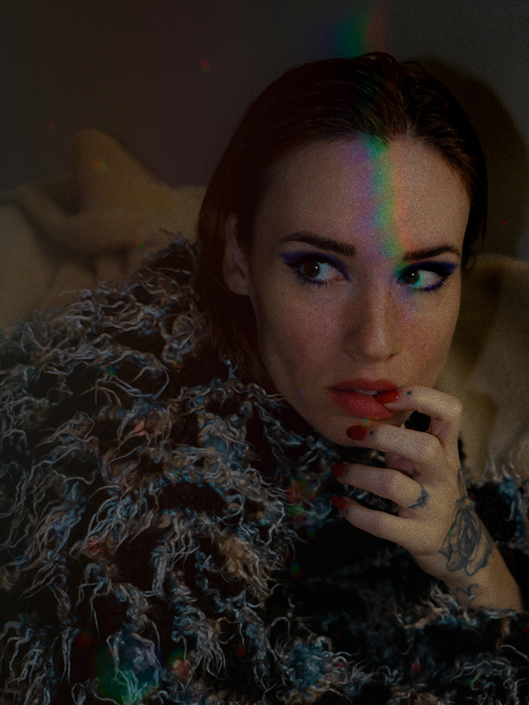 Women with dark hair and fluffy coat with rainbow on har face