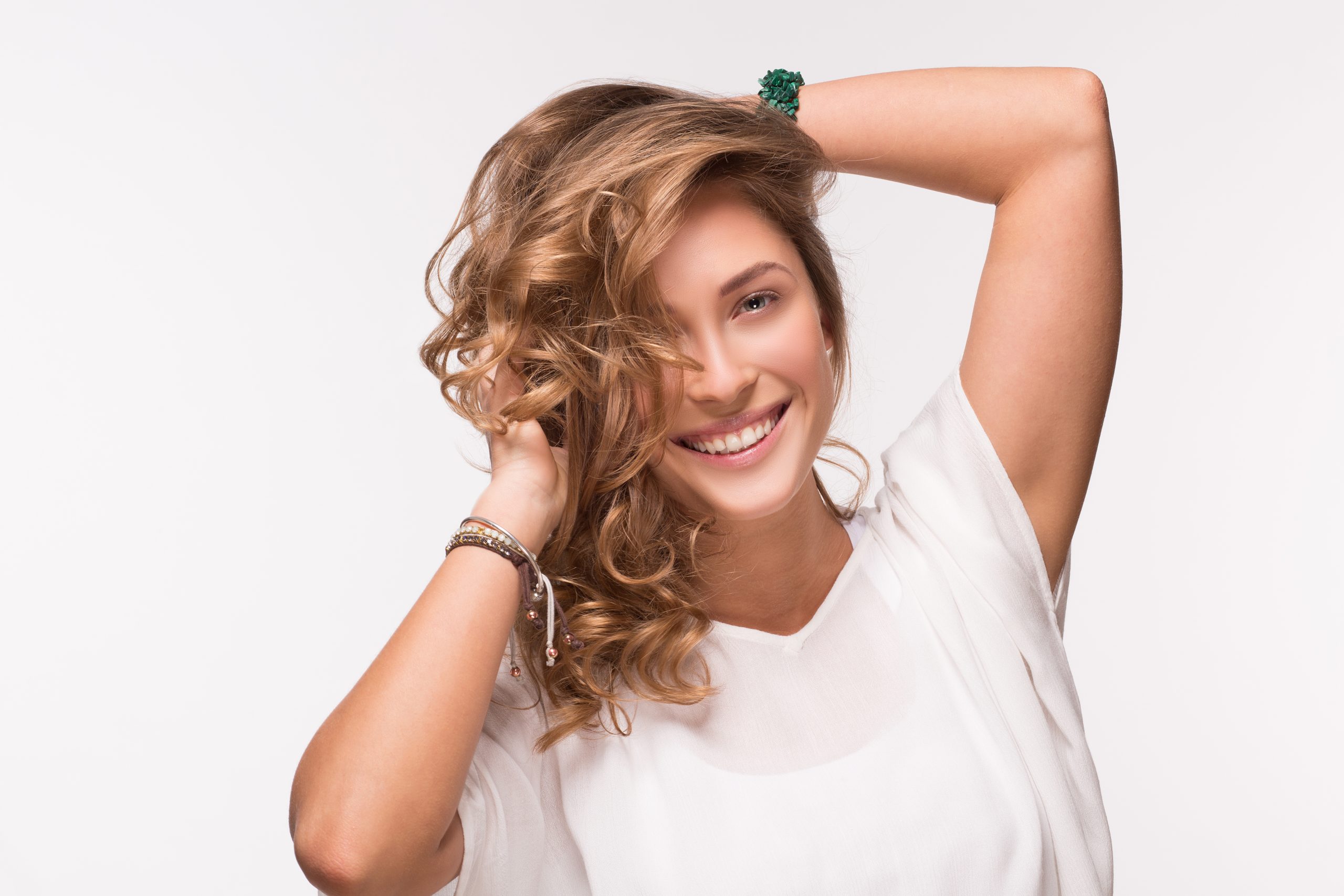 Beautiful blonde woman with long curly hair. Lady in white T-shirt isolated on white background.