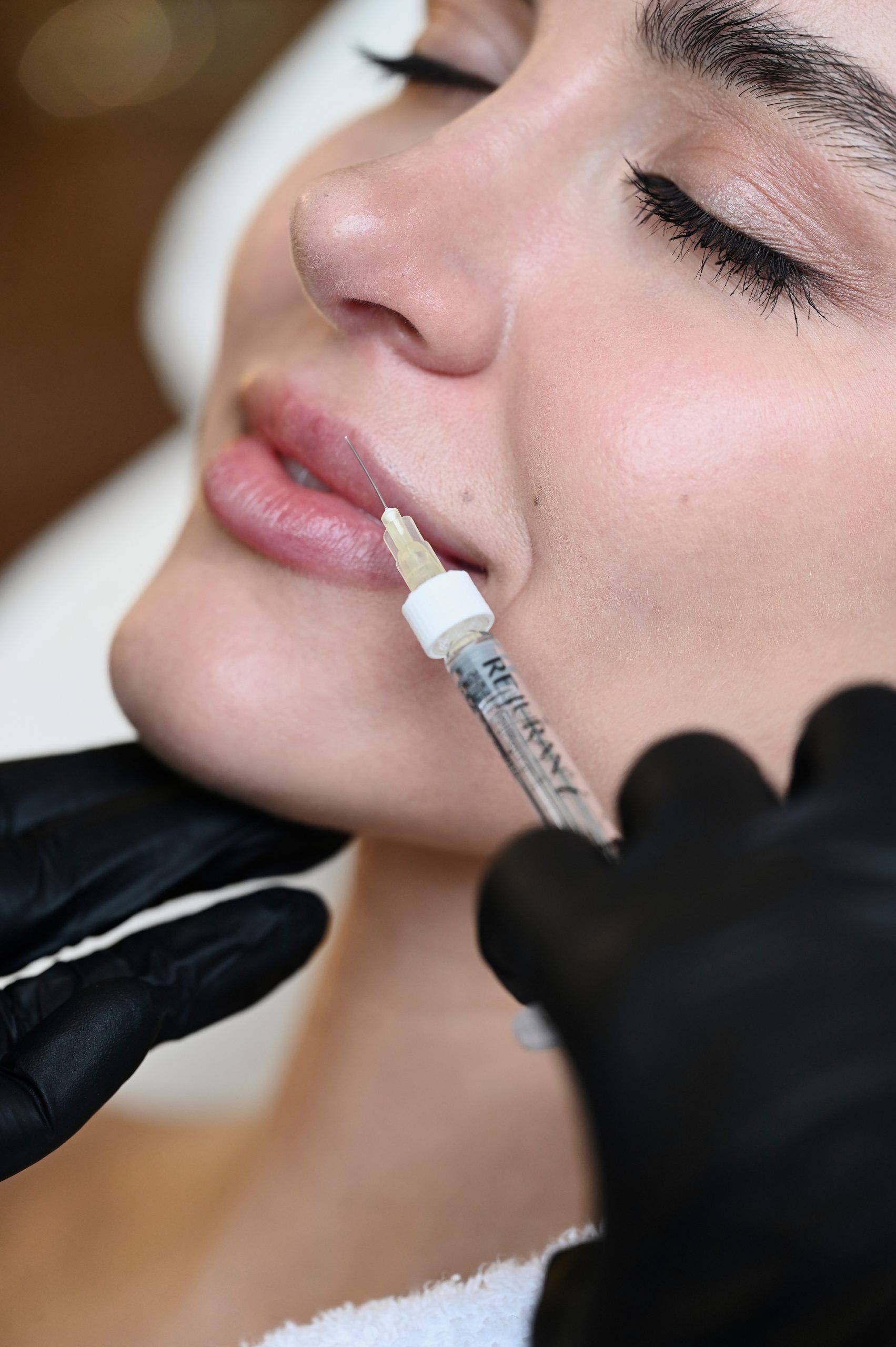 Beauty injection. Woman making correction her nose and lips in salon
