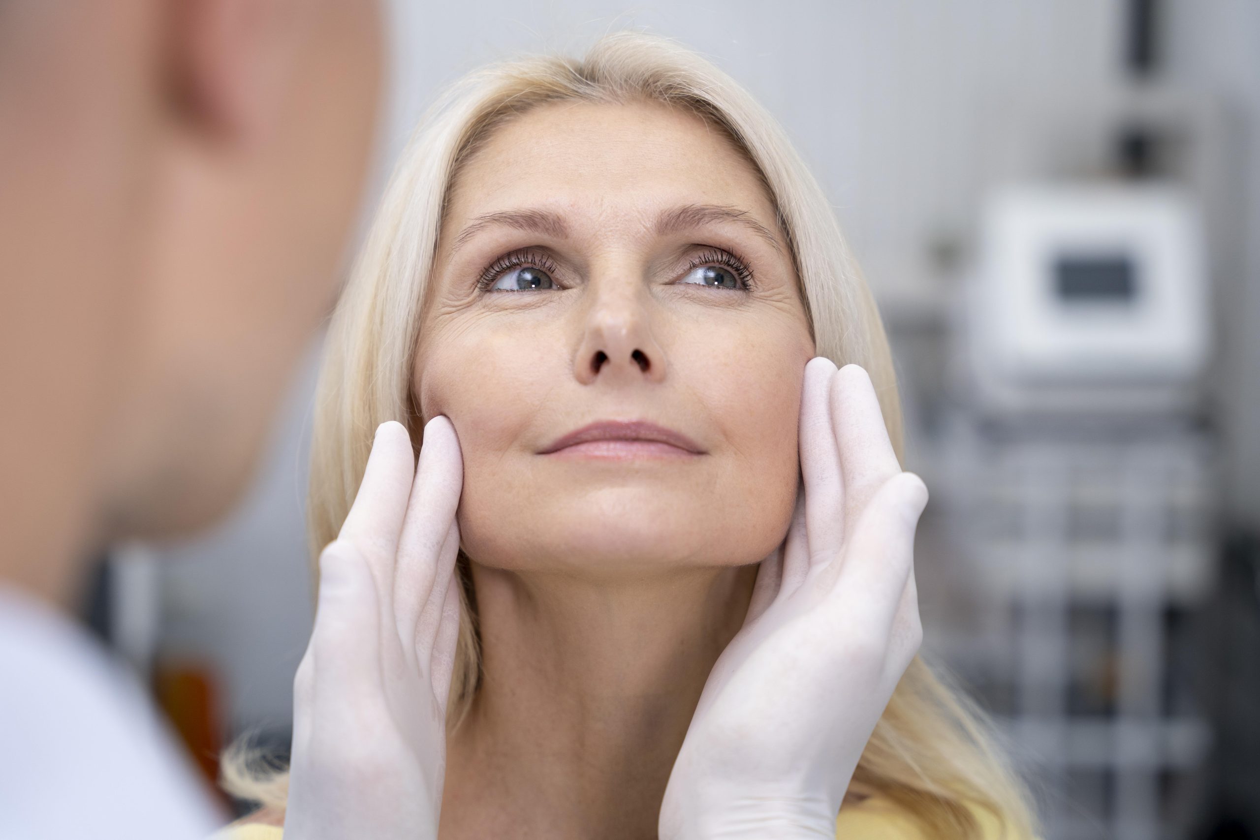 Woman with blond hair who gets checked by a doctor