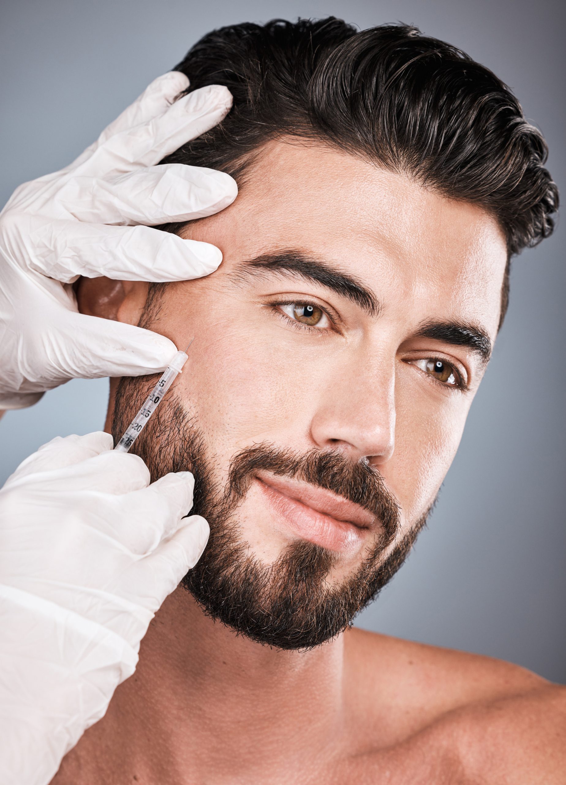 Filler, man and facial injection for skincare, collagen and beauty clinic in studio. Plastic surgery, face needle and male aesthetic for body transformation, cosmetics change and botox on background.