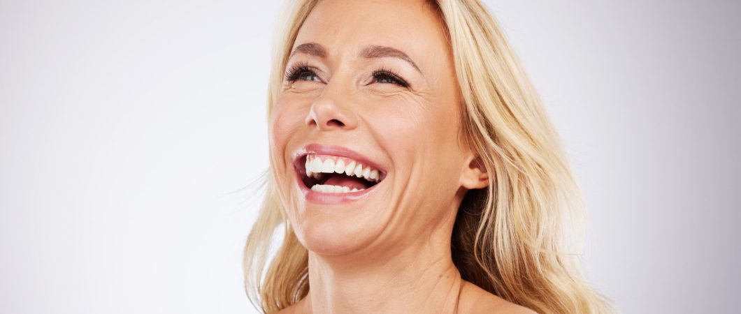 Antiaging, senior and woman beauty laughing, smile and happy for skincare isolated in a studio white background. Mature, old and female model with smooth, wrinkles glow on skin due to cosmetics